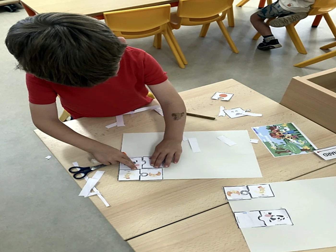 Un élève assemble le puzzle « d’où vient cet aliment ? » à sa table.